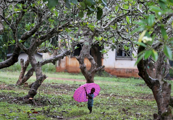 A boy who has been internally displaced walks with an umbrella in the rain in Bambari in October 2015. A fragile peace now prevails in Bambari.