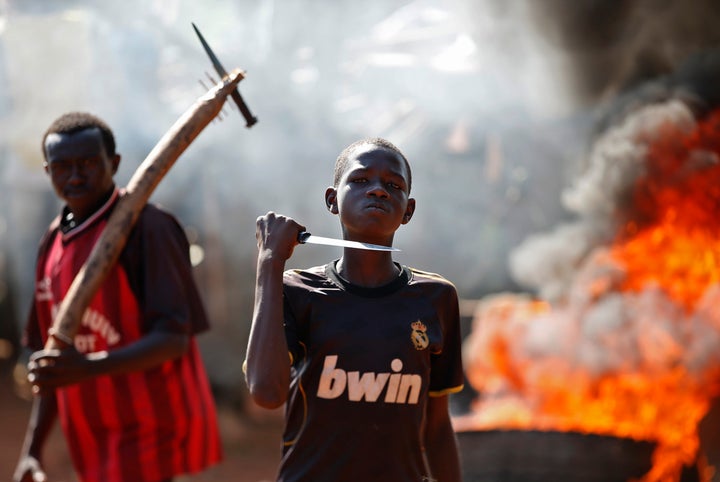A boy gestures in front of a torched barricade during a protest in Bambari in May 2014.