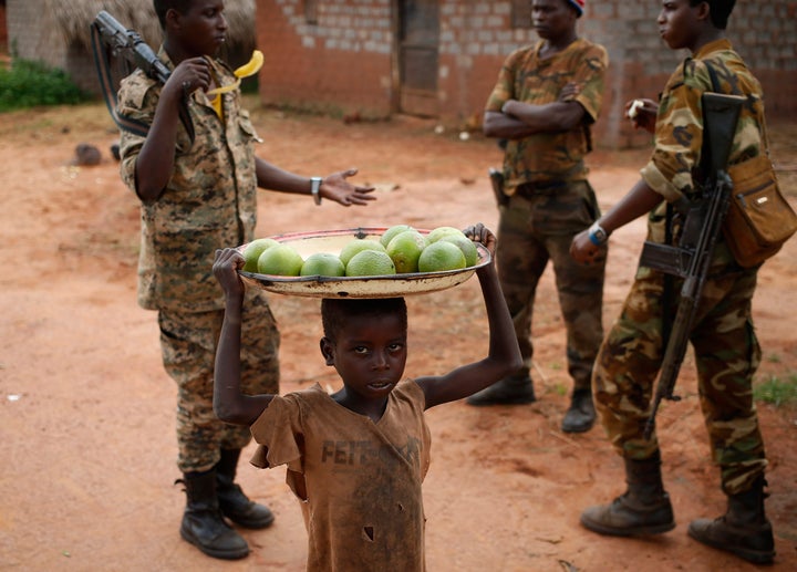 Bambari lies on the front line of the conflict that erupted in the Central African Republic over three years ago. Above, a boy carries oranges to sell to militia fighters near the town in 2014.