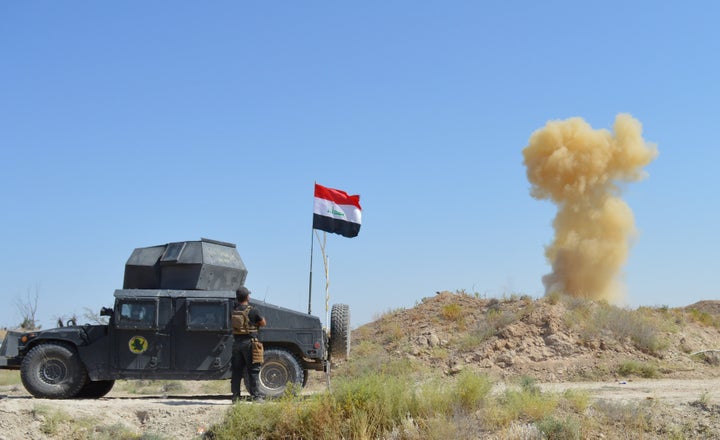 A member of the Iraqi security forces looks on as smoke rises from clashes with Islamic State militants in Fallujah, Iraq on May 31, 2016.