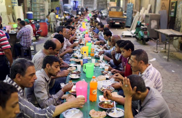 People eat their iftar meal as they break their fast at charity tables that offer free food during the holy fasting month of Ramadan in Cairo, Egypt.
