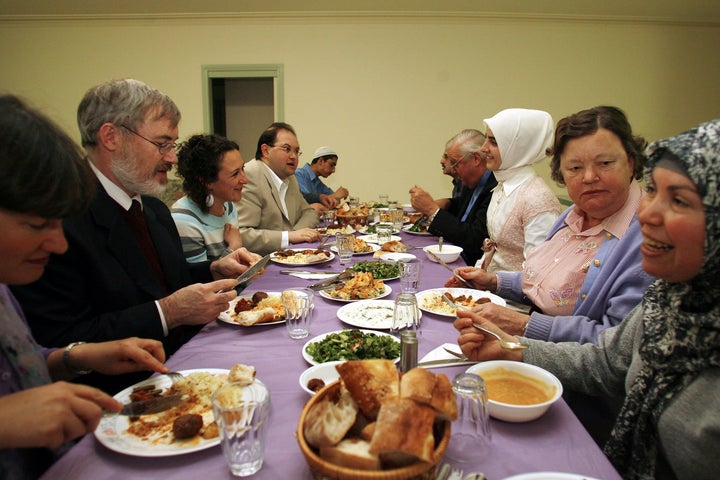 Members of several different religions participating in an interfaith meeting enjoy a traditional Turkish iftar dinner.