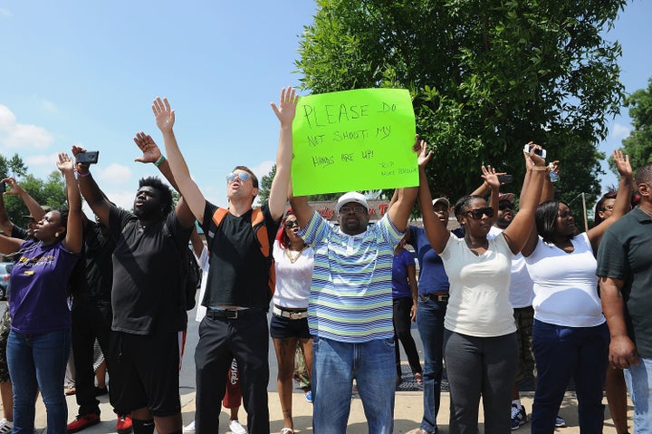 Protesters stand with arms in the air outside the Ferguson Police Department on Aug. 11, 2014.