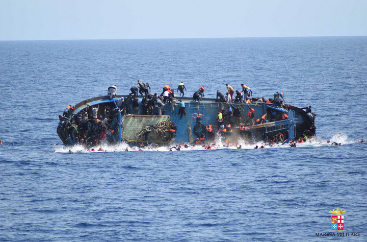 Desperate migrants cling to a capsized boat off the coast of Libya 