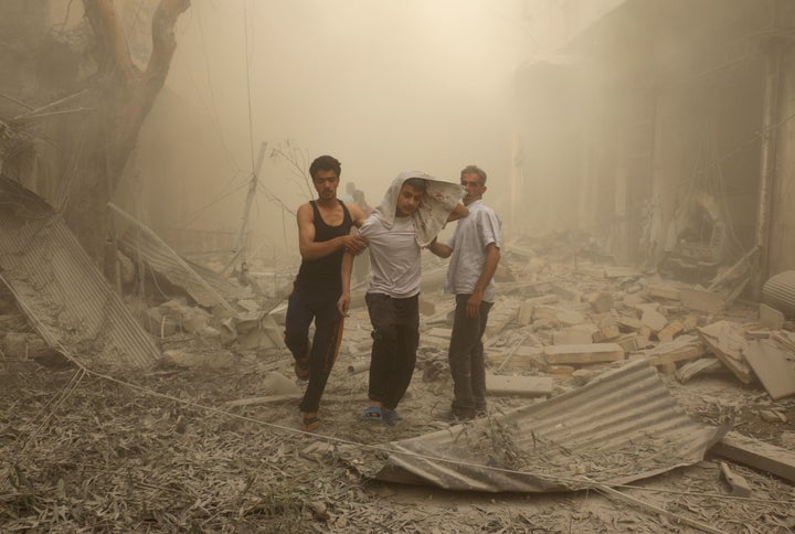 Syrians help a wounded youth after an airstrike on the al Fardous rebel-held neighborhood of Aleppo.