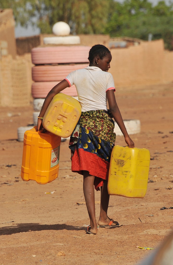 A girl carries plastic jugs to collect water in the poor district of Taptenga suburb of Ouagadougou on May 4, 2016. Burkina Faso will impose restrictions on water supplies in the capital Ouagadougou next week to tackle a serious shortage in the city of two million, officials said. / AFP / AHMED OUOBA (Photo credit should read AHMED OUOBA/AFP/Getty Images)