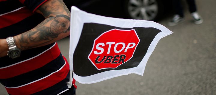 A taxi driver flies a "Stop Uber" flag at a protest in Lisbon, Portugal, on April 29, 2016.