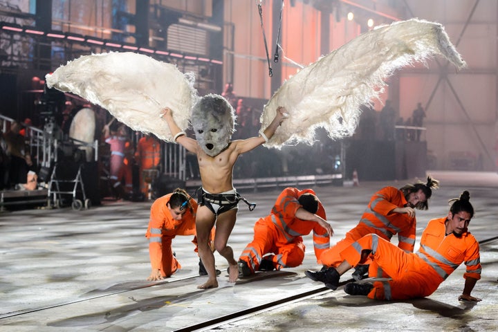 A shirtless performer wearing large wings is seen during Wednesday's opening ceremony for the NEAT Gotthard Base Tunnel.