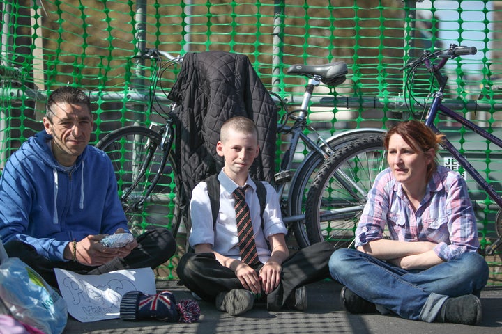 Hamish sits besides Paul Abbasi, left, and Ginna Shandur, right, who receive his sandwiches