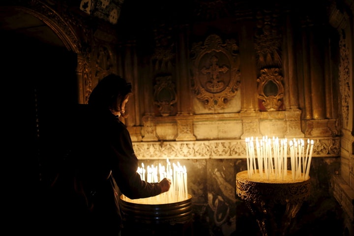 An Armenian woman lights a candle in Jerusalem on April 24, 2015, during a mass marking the 100th anniversary of the&nbsp;Arm