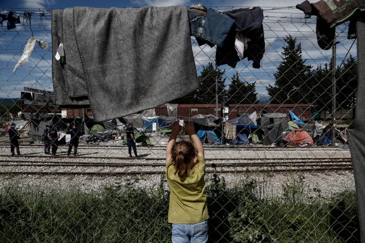 A child looks on as police officers remove tents at the Idomeni refugee camp on the border between Greece and Macedonia on May 25.