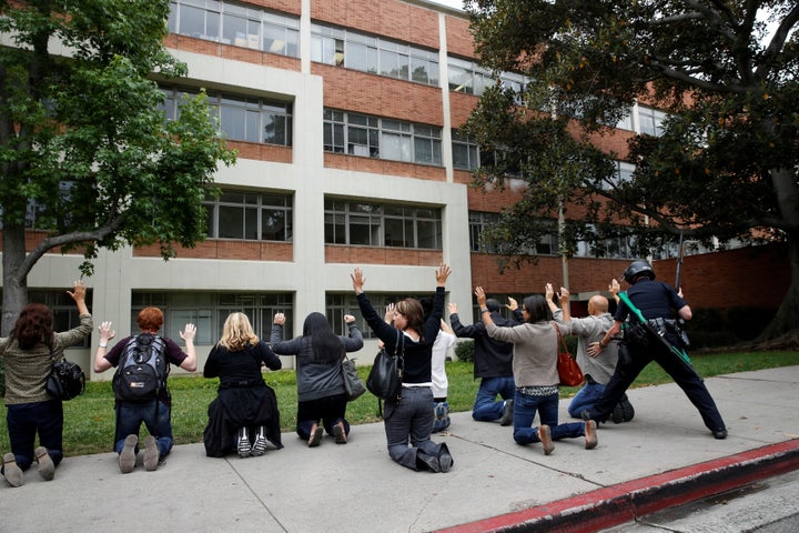 A police officer conducts a search on people at the University of California, Los Angeles (UCLA) campus after it was placed o