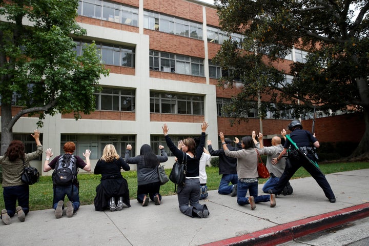 A police officer conducts a search on people at the University of California, Los Angeles (UCLA) campus after it was placed on lockdown following reports of a shooter that left 2 people dead in Los Angeles, California June 1, 2016.