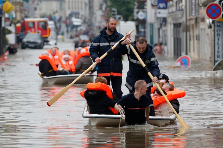 French firefighters evacuate residents from a flooded area after heavy rainfall in Nemours, France, on June 1, 2016.