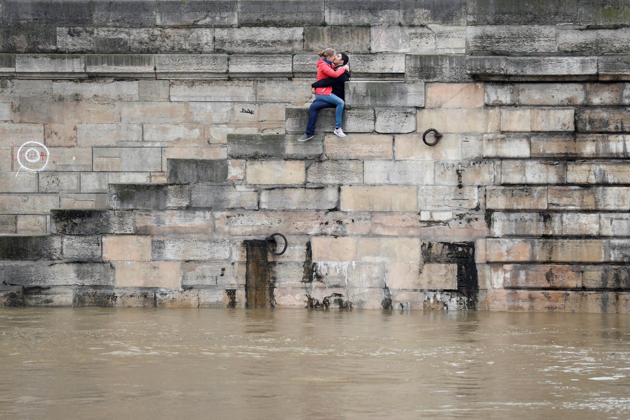 A couple kisses as water rises along the Seine River in Paris on June 1, 2016.