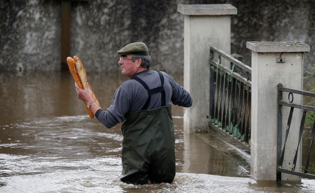 A man brings baguettes to his mother's flooded house in Chalette-sur-Loing Montargis, France, on June 1, 2016.