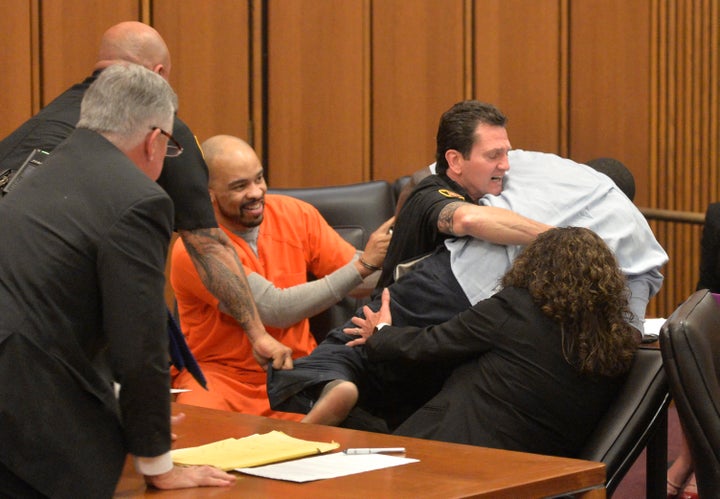 A court officer grabs hold of Van Terry, the grieving father, as killer Michael Madison (in the orange jumpsuit) smiles.