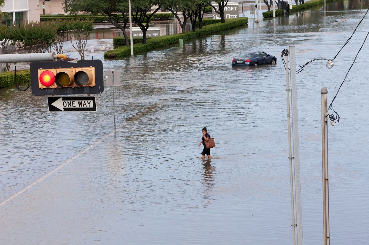A woman walks in the floodwaters in southwest Houston, Texas, on May 26, 2015.