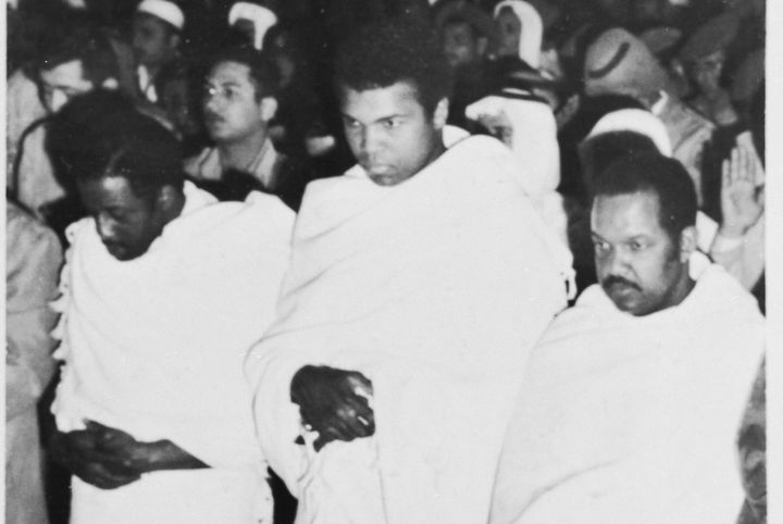 Flanked by fellow pilgrims, Muhammad Ali prays inside a mosque in Mecca during a pilgrimage to the spiritual center of the Muslim world.