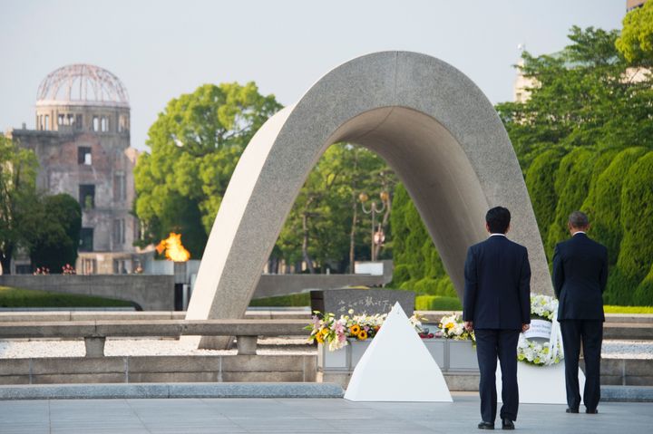 Japanese Prime Minister Shinzo Abe (L) looks on as US President Barack Obama (R) lays a wreath during a visit to the Hiroshima Peace Memorial Park in Hiroshima on May 27, 2016.