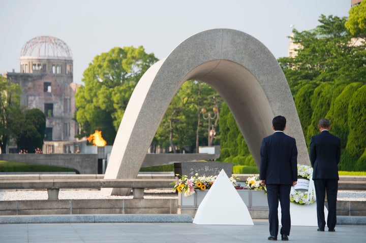 Japanese Prime Minister Shinzo Abe (L) looks on as US President Barack Obama (R) lays a wreath during a visit to the Hiroshim