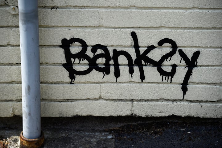 A Banksy signature is seen painted in a bottom corner. The corresponding letter suggested that the students could add to the