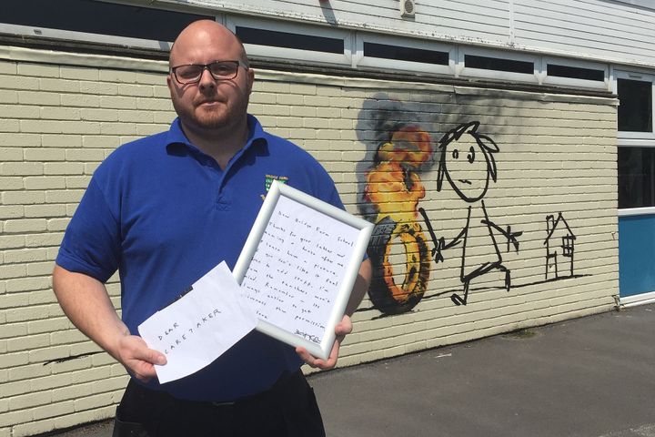 Site manager Jason Brady holds up the letter that was found with the mural on Monday.