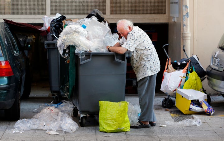 Eugene, an 87-year-old retired Frenchman, searches for food in a garbage container next to a supermarket in Nice June 13, 2013. A former interior decorator, and a pensioner of 24 years, Eugene lives in Nice and is the owner of a small apartment in a bourgeois district of the city. Although he receives a monthly pension of 1000 euros (1300 $US), he started rummaging through trash bins to collect food in 2012, as he did when a teenager during World War II, because 'times are hard' he said. Picture taken June 13, 2013. REUTERS/Eric Gaillard (FRANCE - Tags: SOCIETY POVERTY FOOD)