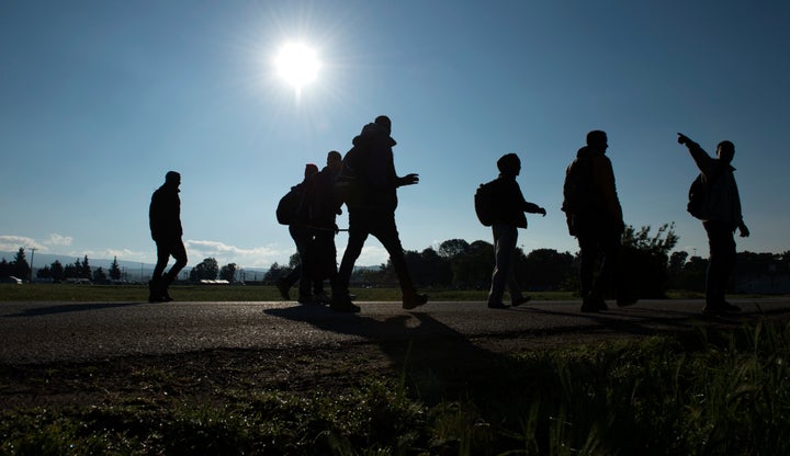 People from Somalia are silhouetted in sunlight as they leave a makeshift camp for migrants and refugees near the village of Idomeni, not far from the Greek-Macedonian border, on April 30, 2016. Some 54,000 people, many of them fleeing the war in Syria, have been stranded on Greek territory since the closure of the migrant route through the Balkans in February. / AFP / TOBIAS SCHWARZ (Photo credit should read TOBIAS SCHWARZ/AFP/Getty Images)