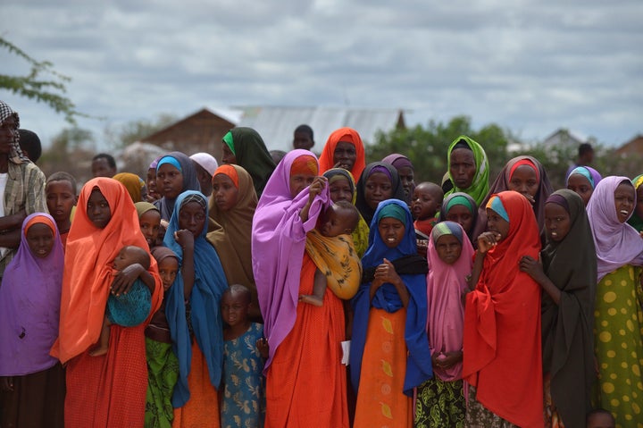 Refugees gather to watch the arrival of United Nations High Commissioner for Refugees Antonio Guterres at IFO-2 complex of the sprawling Dadaab refugee camp on May 8, 2015. Dadaab refugee camp currently houses some 350,000 people and for more than 20 years has been home to generations of Somalis who have fled their homeland wracked by conflicts. But Kenya's government asked the UN refugee agency (UNHCR) to close the camp after an attack on Kenyas Garissa University by Somalia-based Al-Shabaab gunmen in April, whom are suspected to have planned and launched their attack from the camp. AFP PHOTO / TONY KARUMBA