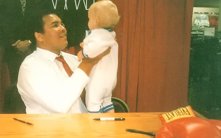 Muhammad Ali holds Riles Alexander, 10 months, during a promotional tour for his cologne at a Dallas, Texas department store in November 1989.
