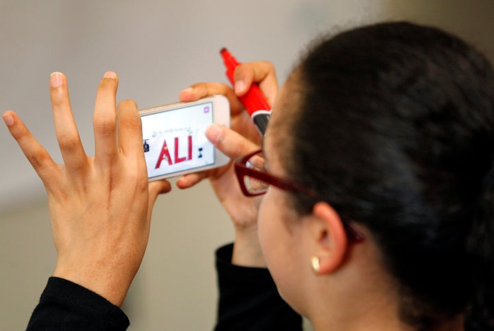 Mona Aner, a member of the Louisville Islamic Center takes a picture of her message on the memorial banner to Muhammad Ali.