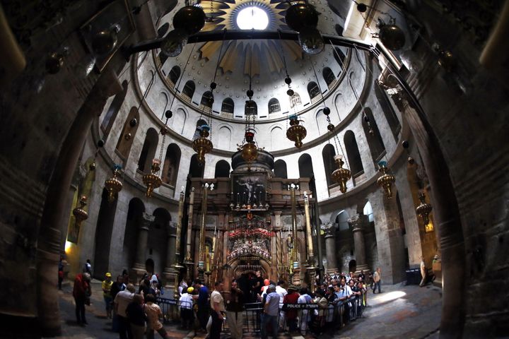 Christian pilgrims gather around the 'Edicule of the Tomb of Jesus Christ' in The Church of the Holy Sepulchre