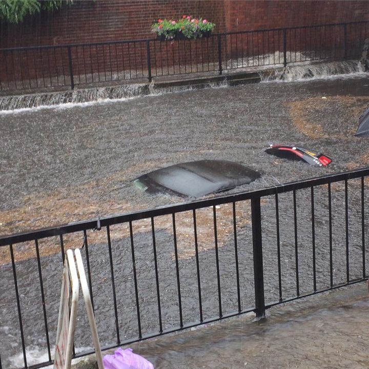 A submerged Mercedes is abandoned in a flooded street in Wallington