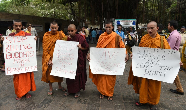 Indian Buddhist monks pose with placards during a silent protest in Mumbai on May 23, 2016, against the murder of an elderly Buddhist monk earlier in the month in Bangladesh