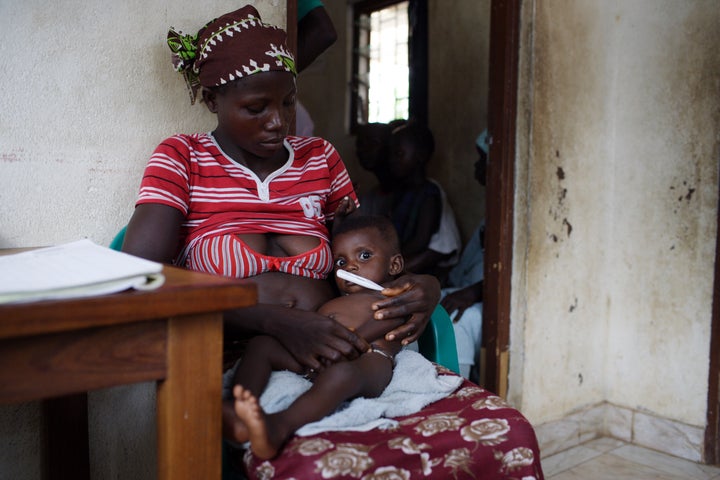 A woman and her children are seen waiting for HIV/AIDS volunteer testing and counseling in Binkolo, Sierra Leone. 