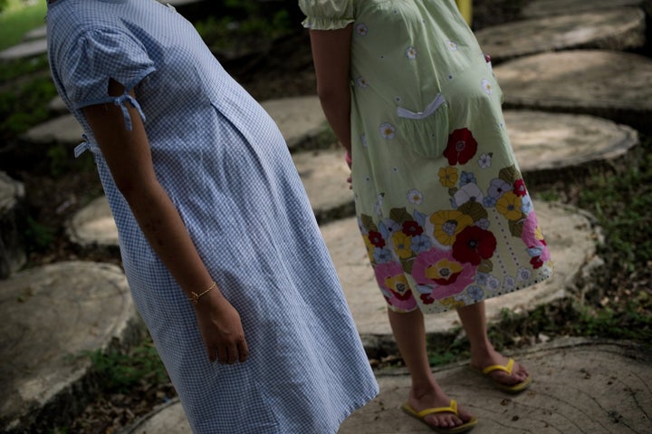 This picture taken on October 29, 2013 shows pregnant teenager Ying (L), 16, standing with another pregnant woman (R) at the