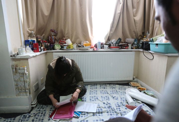 Asylum seekers housed in emergency accommodation study Home Office documents whilst obeying instruction by "hotel management" to keep their curtains drawn shut at all times, on February 29, 2016 in Hillingdon, United Kingdom.