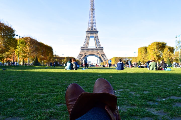 Having a picnic and drinking wine in front of the Eiffel Tower