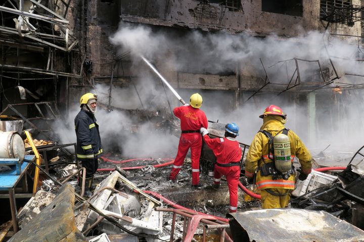 Firemen hose down a burning building at the site of car bomb attack in Baghdad al-Jadeeda, an eastern district of the Iraqi capital.