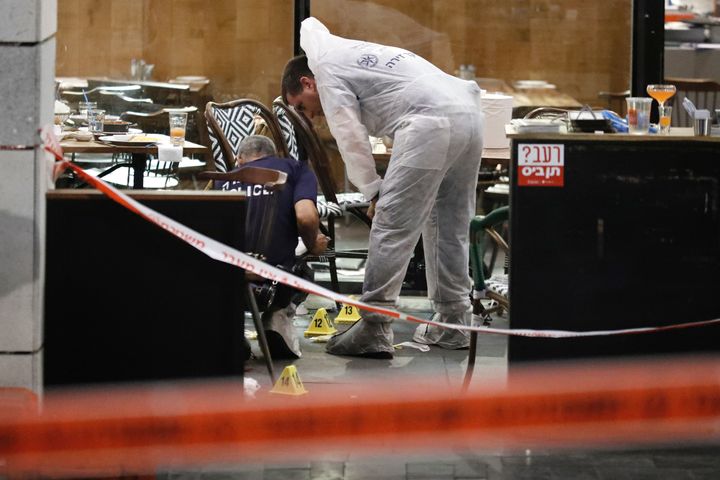 Israeli forensic police inspect a restaurant following the shooting attack at a shopping complex