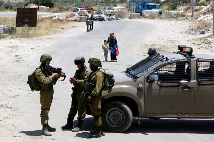 Israeli soldiers stand guard at the entrance of Yatta near the West Bank city of Hebron.