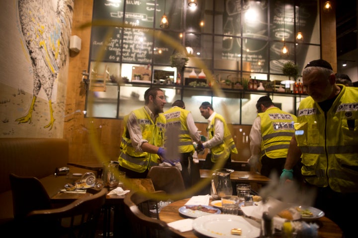 Members of an Israeli ZAKA work the scene of a shooting outside a Max Brenner restaurant in Sarona Market in Tel Aviv.