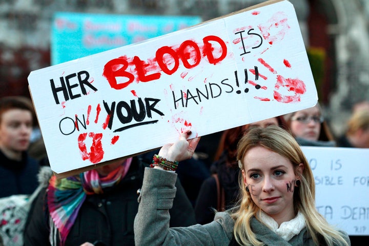 A woman holds a poster during a vigil in November 2012 in Dublin in memory of Savita Halappanavar, who died of septicemia following a miscarriage 17 weeks into her pregnancy. In the U.S., civil rights groups are suing Catholic hospitals over similar cases in which they did not intervene when women were having dangerous miscarriages.