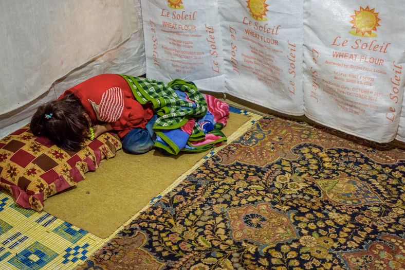 A child refugee lying on a makeshift bed in her home in the Bekaa Valley. 