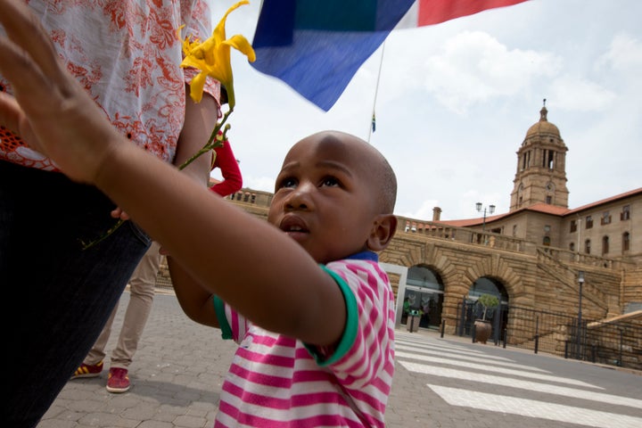 A father and his son holding a South African flag.