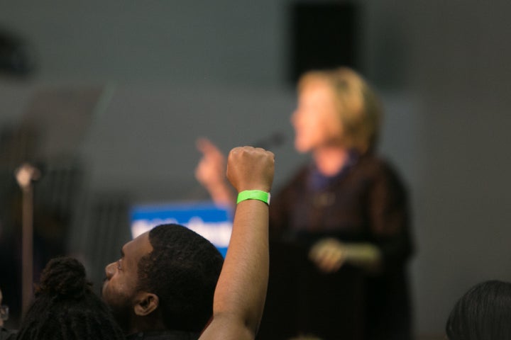 A Black Lives Matter protester throws a fist up as Clinton speaks at an "African Americans For Hillary'' rally in October.