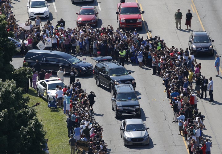 The hearse (center, L) carrying the remains of Muhammad Ali leaves the A D Porter & Sons funeral home during the funeral procession in Louisville, Kentucky