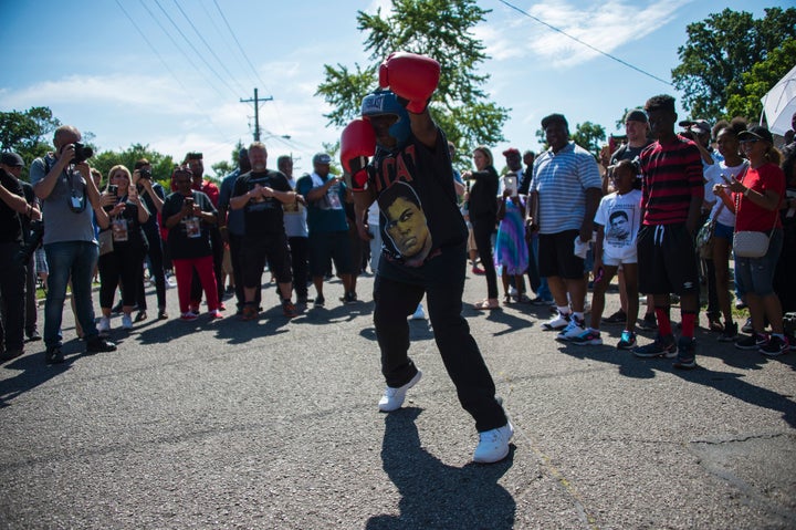 Malik Parker, 13, shadow boxes outside Ali's childhood home where mourners wait to pay their respects