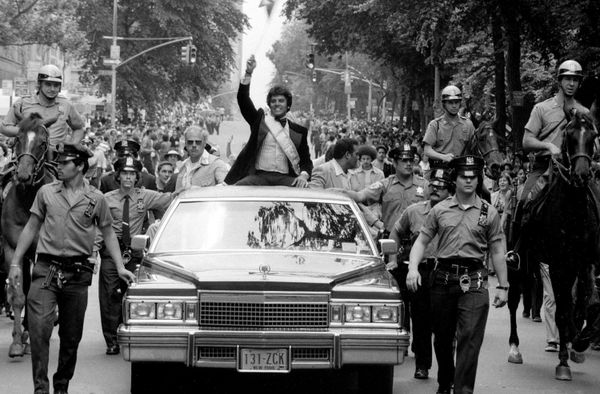 Actor Erik Estrada waves at revelers as he rides down the parade route.